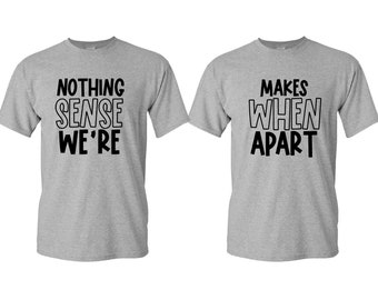 Puede incluir: Dos camisetas grises con texto negro. Una camiseta dice "NOTHING SENSE WE'RE" y la otra "MAKES WHEN APART". Las camisetas son de manga corta y están hechas de un material suave.