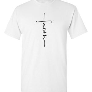 May include: White t-shirt featuring a black handwritten cross design with the word "faith" vertically aligned. The shirt is made of a soft, lightweight material, suitable for casual wear. The design is simple and elegant.