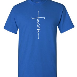 May include: Royal blue t-shirt with a white script design. The design features a cross with the word "faith" written vertically. The shirt has short sleeves and a crew neck.