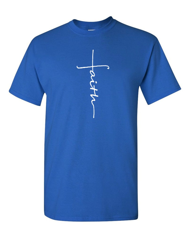 May include: Royal blue t-shirt with a white script design. The design features a cross with the word "faith" written vertically. The shirt has short sleeves and a crew neck.