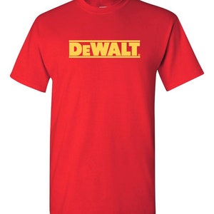 Może przedstawiać: Czerwony t-shirt z okrągłym dekoltem z ż&oacute;łtym napisem "DEWALT". Tekst jest wyśrodkowany i otoczony dwoma ż&oacute;łtymi poziomymi liniami. Koszulka wykonana jest z miękkiego materiału.