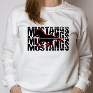 May include: White sweatshirt with a black silhouette of a running horse and the word "Mustangs" repeated three times in black text.