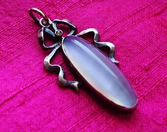Luminous moonstone wrapped in a feminine gem set bow
