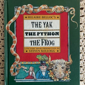 May include: A hardcover book titled Hilaire Belloc's The Yak, The Python, The Frog, a picture book production by Steven Kellogg. The dark green cover features a large orange and yellow python, a green frog, a girl, and a yak with flowers.