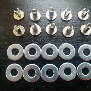 May include: A set of silver metal fasteners with a pointed tip and a flat washer. There are 10 fasteners and 10 washers in total.