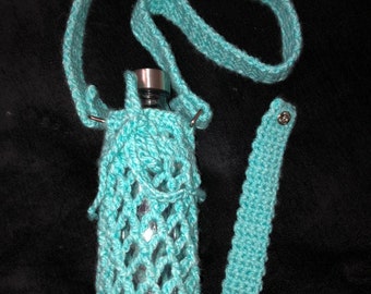 May include: A turquoise crocheted water bottle holder with a matching strap. The holder is made with a delicate open weave pattern and has a silver metal top. The strap has a snap closure. "Angel Artwork Margaret C Herrera" is written in white text at the top of the image.