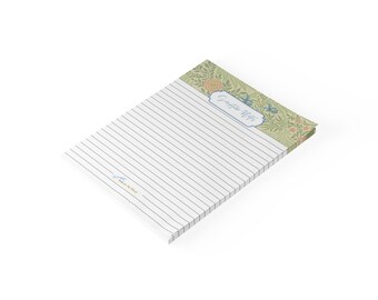 May include: A rectangular notepad with horizontal black lines for writing. The top header features a green background with a floral pattern in orange and blue. A central white label contains the blue cursive text Scripture Notes.