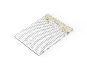 May include: A rectangular notepad featuring a white lined writing area and a top header decorated with a yellow and green floral pattern. The header includes the text Scripture Notes in a blue script font, and the bottom left has small blue text.