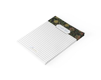 May include: A rectangular notepad with white lined paper featuring a dark botanical header with green leaves and pomegranates. The header includes a white label with the text Scripture Notes in blue script. A small blue logo is at the bottom left.