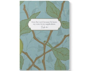 May include: A rectangular notebook with a light blue background featuring a pattern of brown branches and green leaves. Centered on the cover is a white label with a dark border containing the text: I love the Lord, because He hears my voice & my supplications. Psalm 116:1.