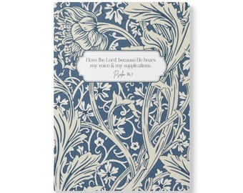 May include: A rectangular notebook featuring a dark blue and cream-coloured floral pattern. Centred on the cover is a white label with the text: I love the Lord, because He hears my voice & my supplications. Psalm 116:1, enclosed in a thin border.
