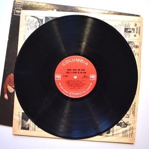 May include: A black vinyl record with a red label. The label says "Columbia" and "Blood, Sweat and Tears, Child is Father to the Man,  C1 9619, 360 Sound Stereo 360 Sound".