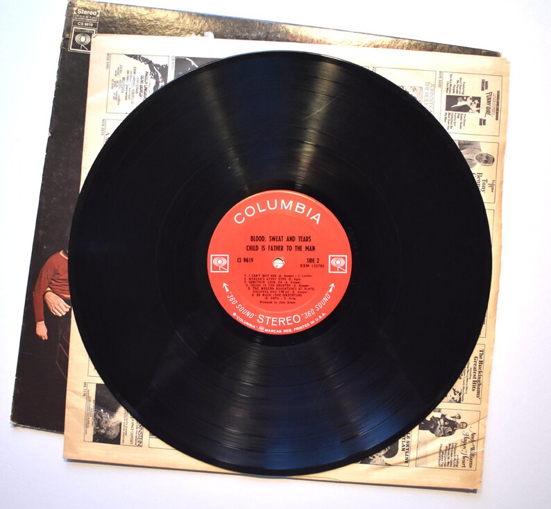 May include: A black vinyl record with a red label. The label says "Columbia" and "Blood, Sweat and Tears, Child is Father to the Man,  C1 9619, 360 Sound Stereo 360 Sound".
