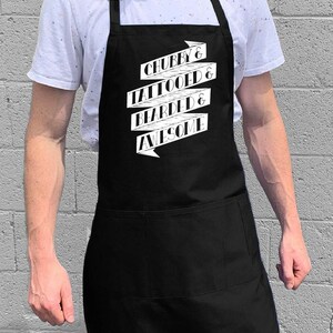 Puede incluir: Un delantal negro con una pancarta blanca que dice "Chubby & Tattooed & Bearded & Awesome".