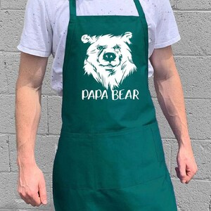 May include: A green apron with a white bear graphic and the text "Papa Bear".