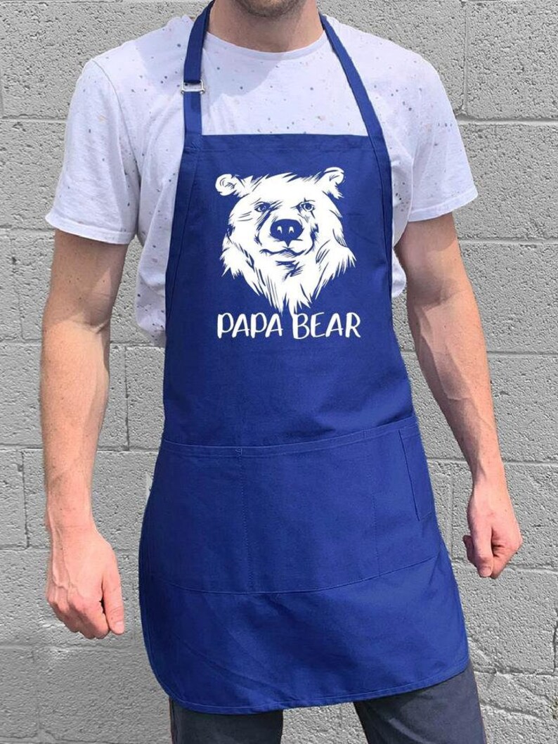 May include: A blue apron with a white bear graphic and the text "Papa Bear".