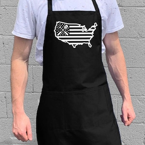May include: Black apron with a white outline of the United States of America with a crossed spatula and fork in the center. The apron has a large pocket.