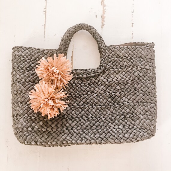 straw tote with pom poms