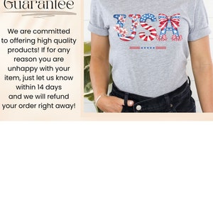May include: A gray t-shirt with a red, white, and blue USA graphic featuring flowers, candy canes, and bows. The text "Happiness Guarantee" is visible in the background.