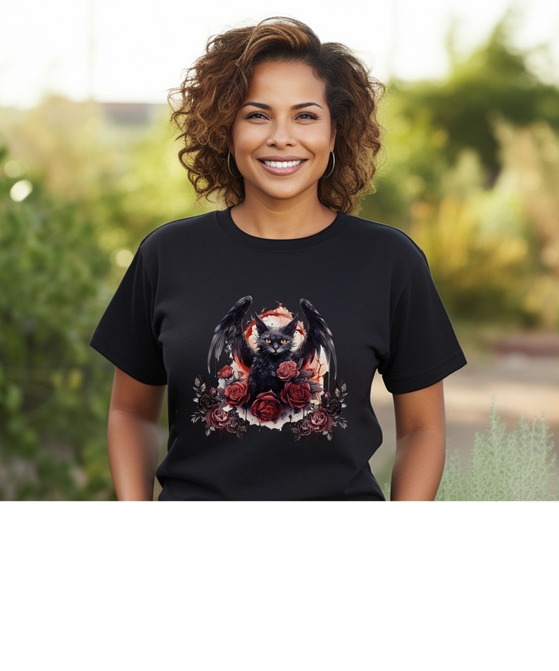 May include: Black t-shirt featuring a graphic of a black cat with bat wings, surrounded by red roses. The cat has yellow eyes and is set against a red and white background. The design is centered on the front of the shirt.