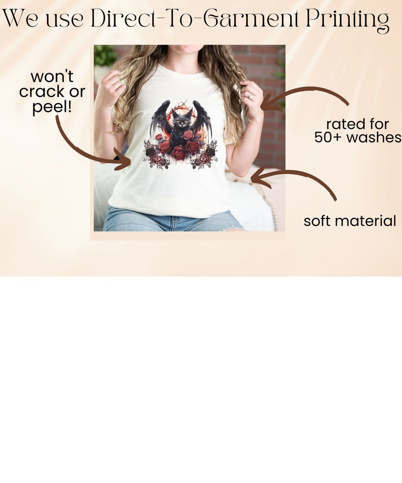 May include: Cream-colored t-shirt featuring a black cat with bat wings, surrounded by red roses, and a crescent moon. The shirt has the text "We use Direct-To-Garment Printing" at the top. The shirt is rated for 50+ washes and made of soft material.