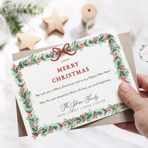 May include: A Christmas card with a watercolor wreath border and the text "2023 Merry Christmas". The card also includes the text "We wish you a Merry Christmas and a very Happy New Year! May the year ahead be filled with love, joy and happiness." and the text "The Johnson Family JACK | EMILY | ANNA | JACOB".