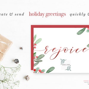 Op de afbeelding: Een witte kaart met een rode rand en een aquarel-illustratie van groene bladeren en rode bessen. De tekst "rejoice" is geschreven in rode cursieve letters. De kaart is voor kerstgroeten.