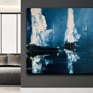 Könnte beinhalten: Abstraktes Ölgemälde von Booten auf dem Wasser. Das Kunstwerk zeigt dunkelblaue und weiße Pinselstriche mit Reflexionen im Wasser. Die Boote haben gelbe Akzente, die einen Kontrast bilden. Das Gemälde wird in einem modernen Schlafzimmer ausgestellt.