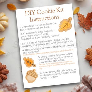 May include: A DIY cookie kit instruction sheet with fall-themed decorations. The sheet includes instructions for decorating cookies with icing and sprinkles. The image also features decorative pumpkins, leaves, and bowls of ingredients.