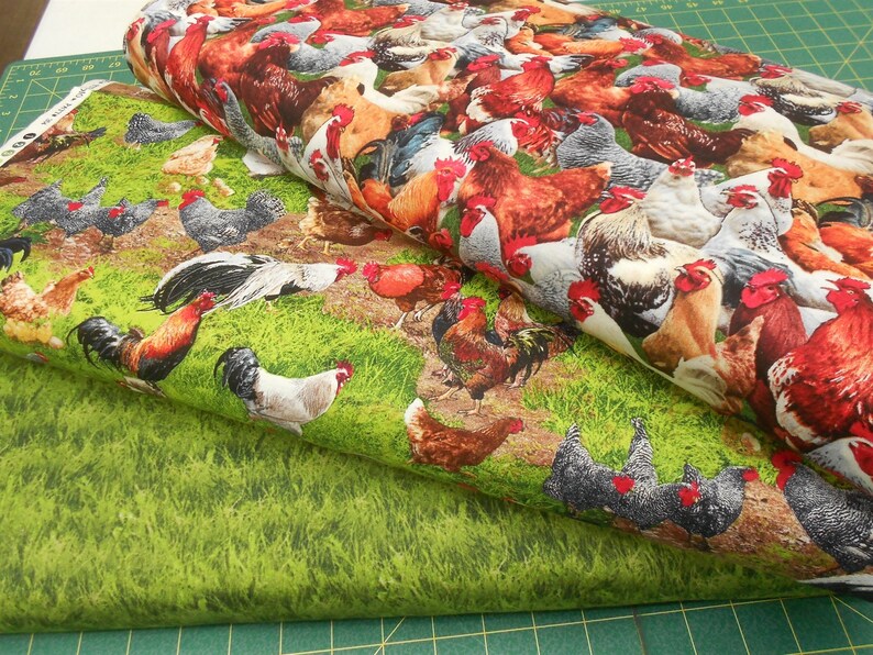 May include: Two pieces of fabric featuring a repeating pattern of colourful roosters and hens against a green grassy backdrop.