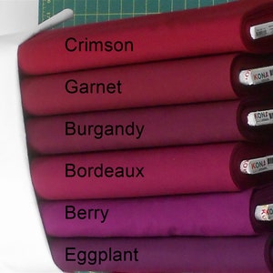 May include: Six fabric swatches in various shades of red and purple, from crimson to eggplant. The swatches are labeled with the color names: Crimson, Garnet, Burgundy, Bordeaux, Berry, and Eggplant.