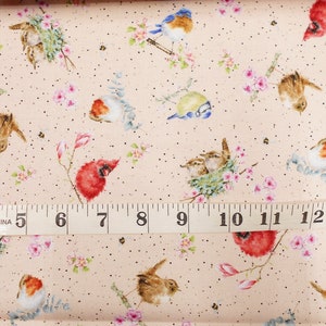 May include: A pink fabric with a repeating pattern of birds, flowers, and leaves. The fabric is measured with a tape measure that reads 4 to 13 inches.