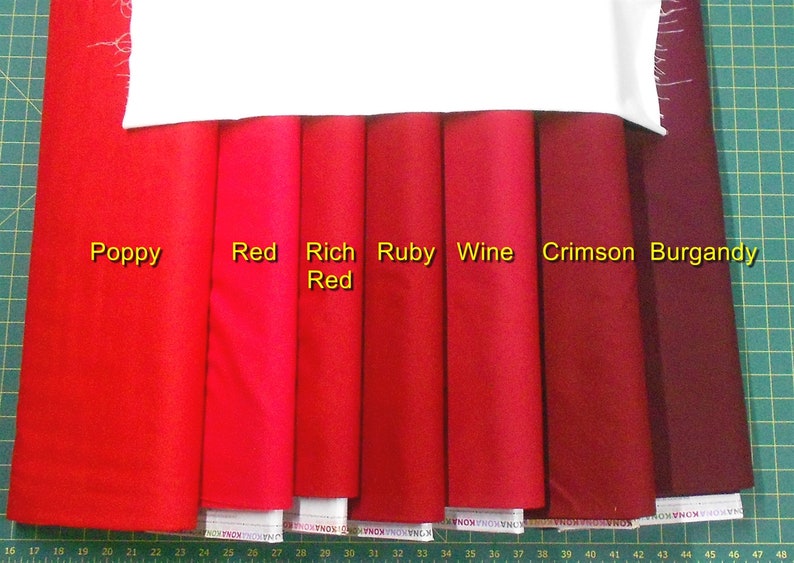 May include: A comparison of eight different shades of red fabric swatches, labeled "Poppy", "Red", "Rich Red", "Ruby", "Wine", "Crimson", and "Burgandy".