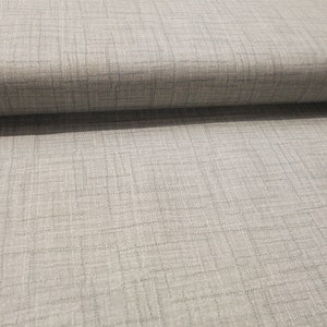 May include: A close-up of a light gray fabric with a subtle woven pattern. The fabric has a slightly textured surface.