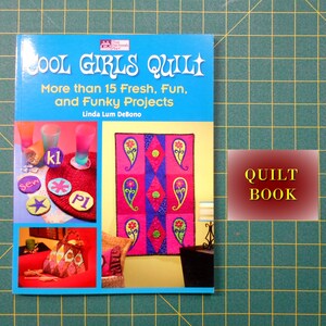 May include: A blue book titled "Cool Girls Quilt" with the subtitle "More than 15 Fresh, Fun, and Funky Projects" by Linda Lum DeBono. The book cover features colorful quilt designs and the text "QUILT BOOK" in a red and gold rectangle.