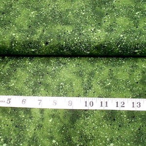 May include: Green fabric with a white and black speckled pattern. The fabric is folded in half and a measuring tape is placed on top of the fabric. The measuring tape reads 3 to 15 inches.