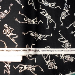 Peut inclure: Tissu noir avec un motif blanc r&eacute;p&eacute;t&eacute; de squelettes dansant. Le tissu a une &eacute;tiquette blanche qui indique "Riley Blake Designs&trade; Pattern C13939 Hester & Cook &copy;2023 All Rights Reserved - www.RileyBlakeDesigns.com"