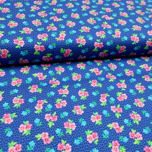 May include: Blue fabric with a repeating pattern of pink and blue flowers. The fabric has a subtle textured background.
