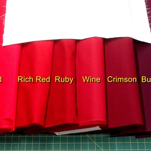May include: Six fabric swatches in different shades of red, from bright red to burgundy. The swatches are labeled "Red", "Rich Red", "Ruby", "Wine", "Crimson", and "Burgundy".