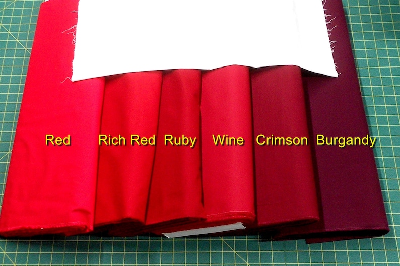 May include: Six fabric swatches in different shades of red, from bright red to burgundy. The swatches are labeled "Red", "Rich Red", "Ruby", "Wine", "Crimson", and "Burgundy".