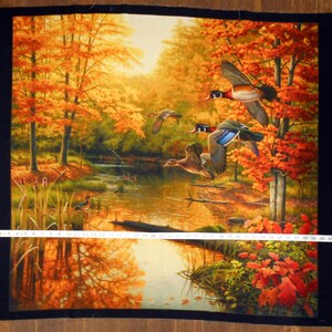 May include: A painting of a forest scene with a stream running through it. The trees are in autumn colors of orange, yellow, and red. There are three ducks flying over the stream.