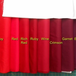 May include: Eight fabric swatches in shades of red, from bright poppy red to deep burgundy. The swatches are labeled "Poppy", "Red", "Rich Red", "Ruby", "Wine Crimson", "Garnet", and "Burgundy".