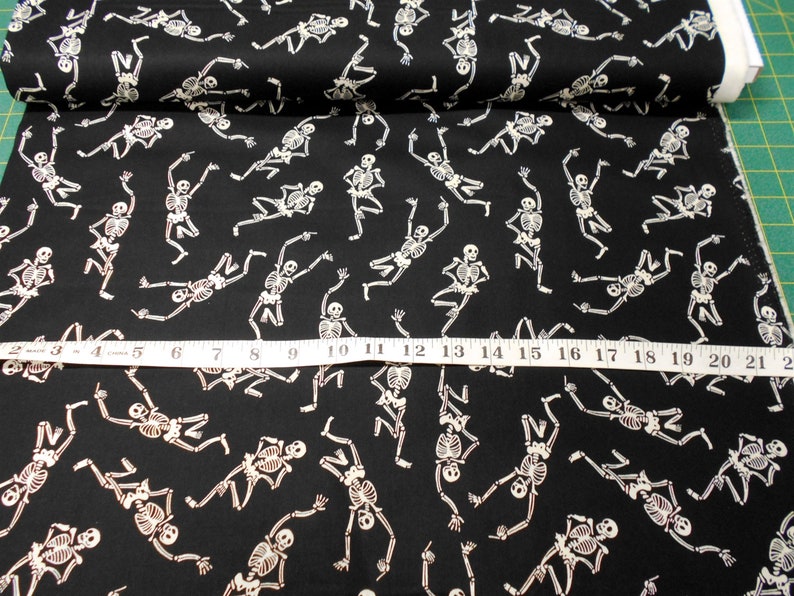Peut inclure: Tissu noir avec un motif de squelettes blancs. Les squelettes dansent et ont un aspect amusant et fantaisiste. Le tissu est parfait pour les projets et les travaux manuels d'Halloween.