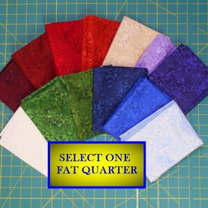 May include: A collection of fat quarters in various colors, including red, green, blue, and purple. Each fabric square features a swirling pattern. The image includes a yellow rectangle with the text "SELECT ONE FAT QUARTER".