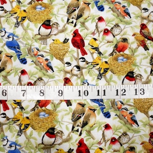 May include: A white fabric with a repeating pattern of colorful birds, including cardinals, blue jays, and yellow finches. The birds are perched on branches and in nests. A measuring tape is included in the image.