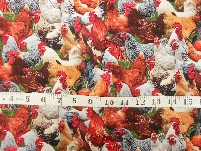 May include: A colourful fabric featuring a repeating pattern of roosters and hens. The fabric is a mix of brown, white, red, and black colours. The fabric is measured with a tape measure.