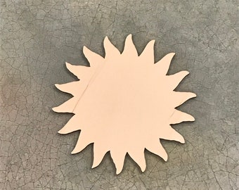 May include: A wooden sun cutout with a light brown color. The sun has a simple design with 12 points.