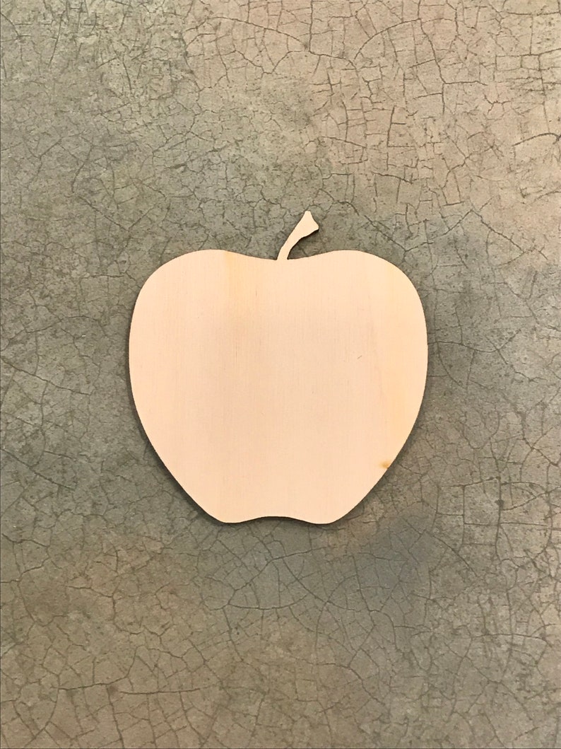 May include: A wooden apple-shaped cutout with a stem. The cutout is made of light-colored wood and has a smooth surface. The apple shape is a simple, clean design, perfect for crafts or decorations.