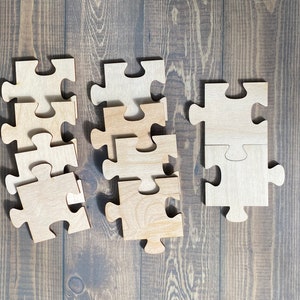 May include: A set of wooden puzzle pieces on a brown wooden background. The pieces are all the same size and shape, and they are arranged in a random pattern. Some of the pieces are missing, creating a sense of incompleteness.