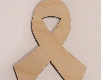 Puede incluir: Un recorte de madera de una cinta en forma de lazo. La cinta es de color marrón claro y tiene una superficie lisa.